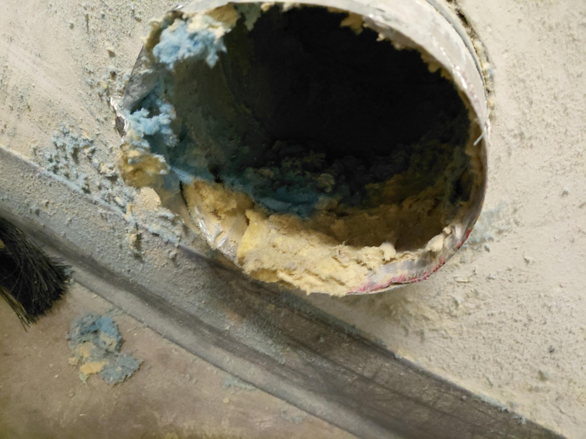 Duct opening with visible fibrous material.
