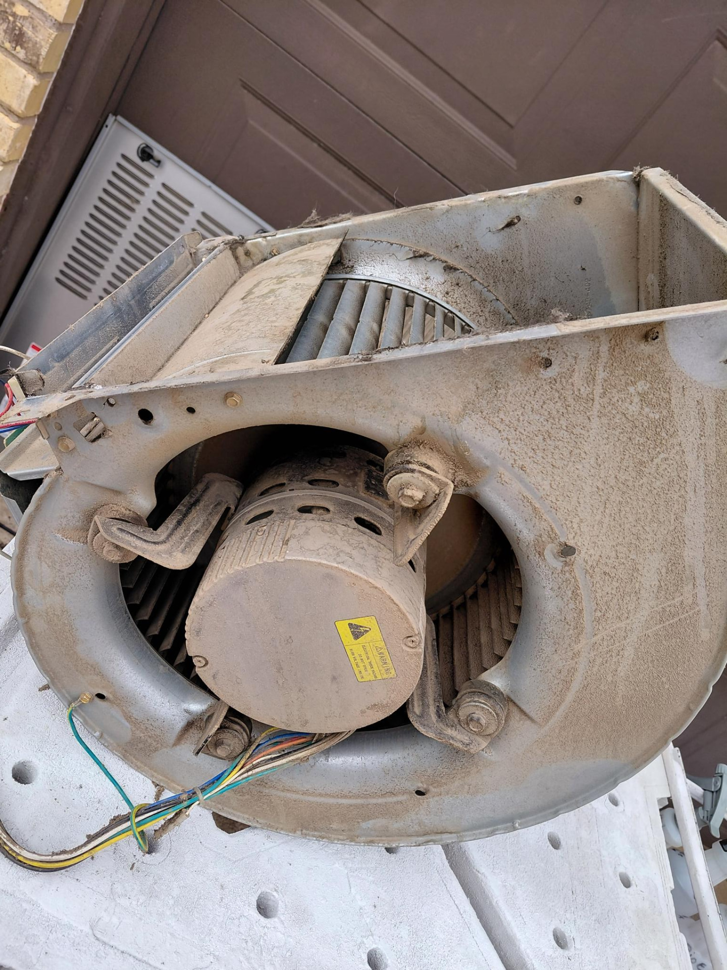 Blower motor assembly with visible surface buildup.